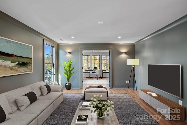 living room featuring ceiling fan, wood-type flooring, and ornamental molding