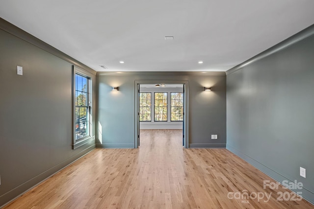 unfurnished room with crown molding and light wood-type flooring