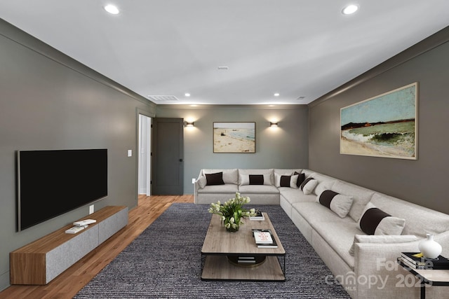 living room with wood-type flooring and ornamental molding