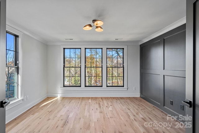 interior space with ornamental molding and light hardwood / wood-style flooring