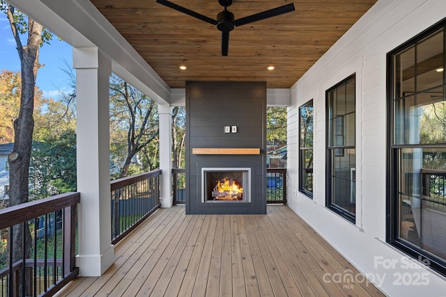 deck with ceiling fan and a fireplace