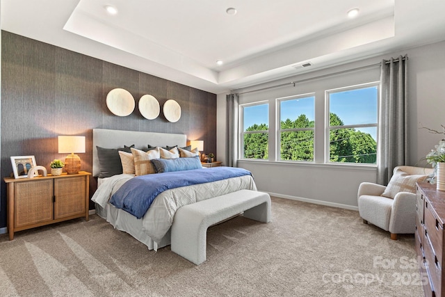 carpeted bedroom with a tray ceiling