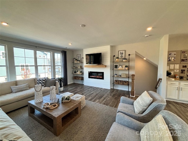 living room with a fireplace and dark wood-type flooring