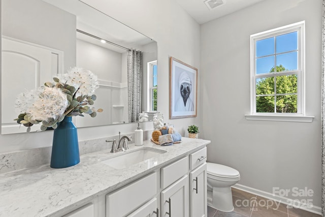 bathroom with a shower with shower curtain, tile patterned floors, vanity, and toilet