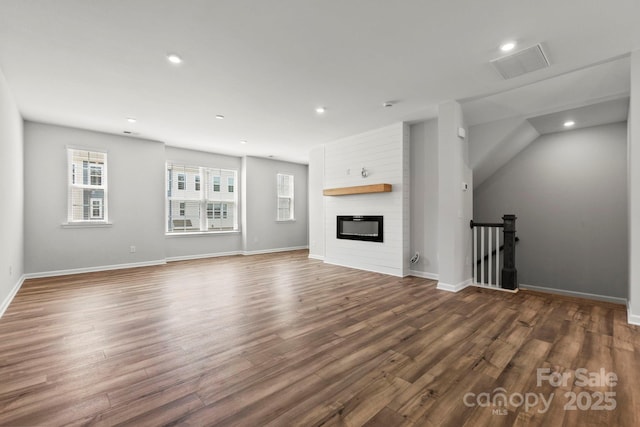 unfurnished living room with a large fireplace and dark hardwood / wood-style flooring