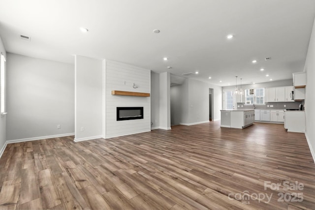 unfurnished living room with a large fireplace and light wood-type flooring