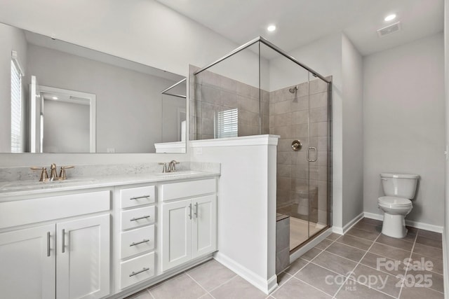 bathroom featuring vanity, toilet, walk in shower, and tile patterned floors