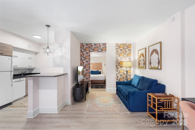 living room with light hardwood / wood-style floors and sink