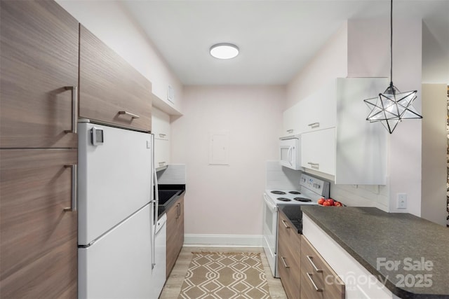 kitchen with white cabinetry, backsplash, pendant lighting, white appliances, and light wood-type flooring