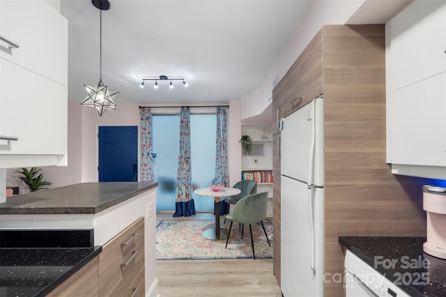 kitchen with hanging light fixtures, an inviting chandelier, light hardwood / wood-style flooring, white fridge, and white cabinets