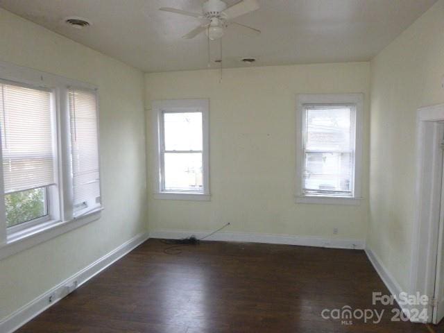 unfurnished room with ceiling fan and dark wood-type flooring