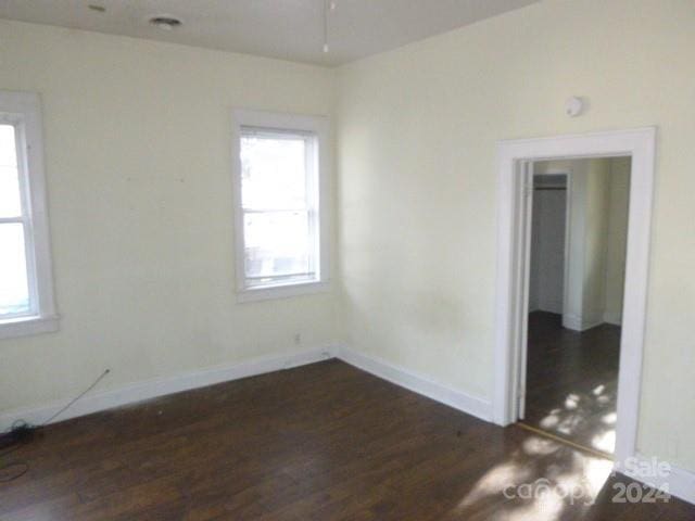 unfurnished room with a healthy amount of sunlight and dark hardwood / wood-style flooring