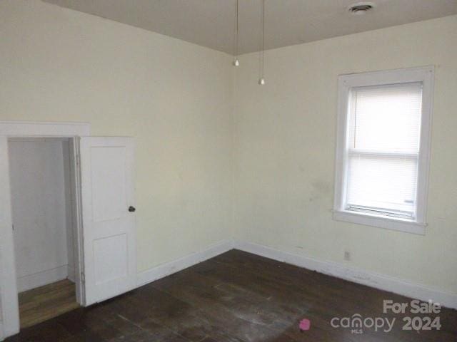 spare room with dark wood-type flooring