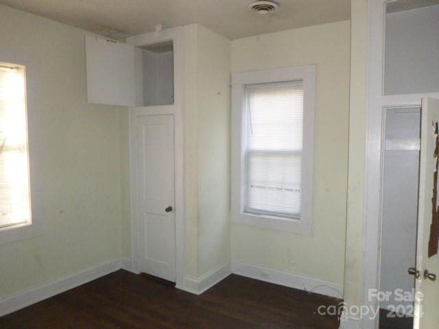 interior space with multiple windows and dark wood-type flooring