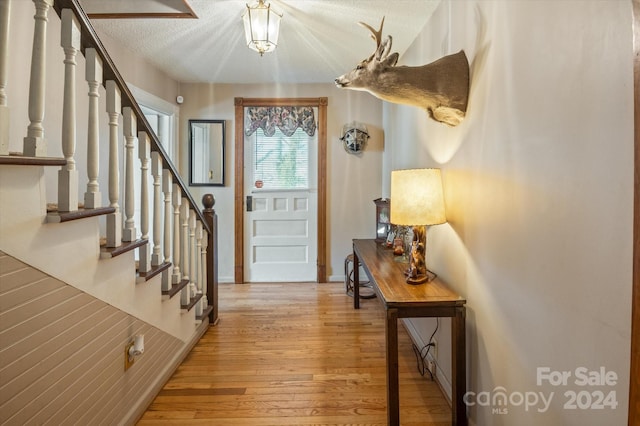 foyer featuring a textured ceiling and light hardwood / wood-style floors