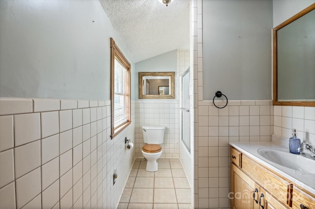 full bathroom with tile patterned floors, bath / shower combo with glass door, a textured ceiling, vaulted ceiling, and tile walls