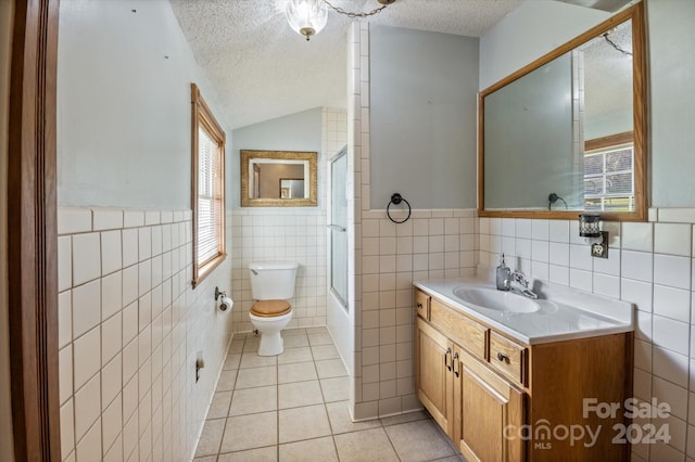 full bathroom with a textured ceiling, tile walls, and a healthy amount of sunlight