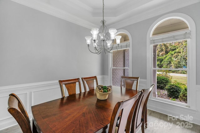 dining room featuring crown molding, a tray ceiling, and a chandelier