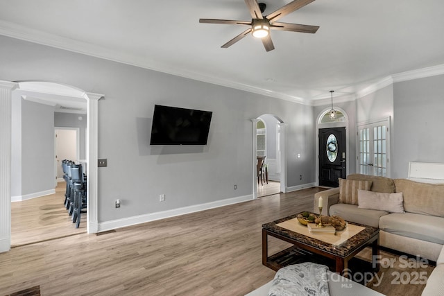 living room with hardwood / wood-style flooring, ornamental molding, decorative columns, and ceiling fan