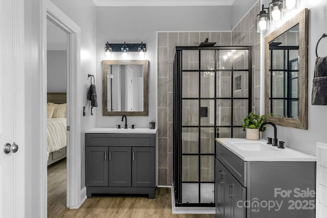 bathroom featuring tiled shower, vanity, and hardwood / wood-style floors