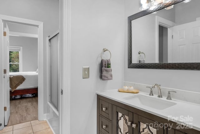 bathroom with tile patterned flooring, vanity, and bath / shower combo with glass door