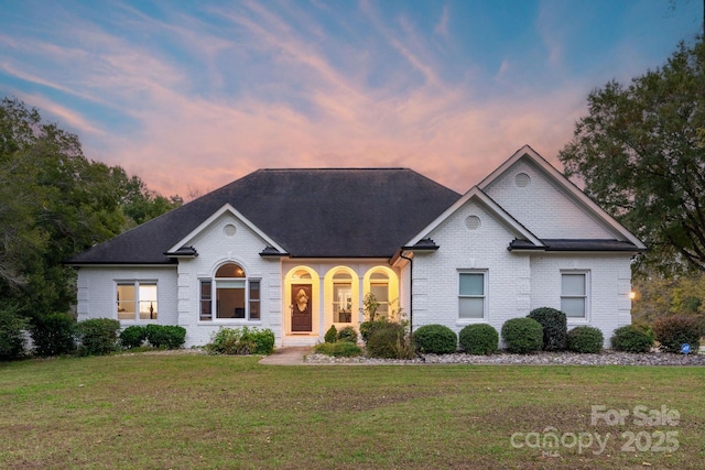 ranch-style home featuring a lawn