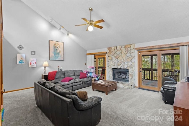 carpeted living room with a fireplace, ceiling fan, high vaulted ceiling, and track lighting