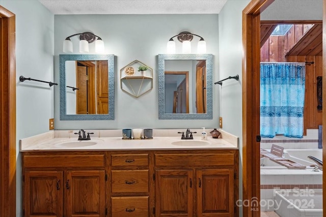 bathroom featuring vanity, a tub, and a textured ceiling