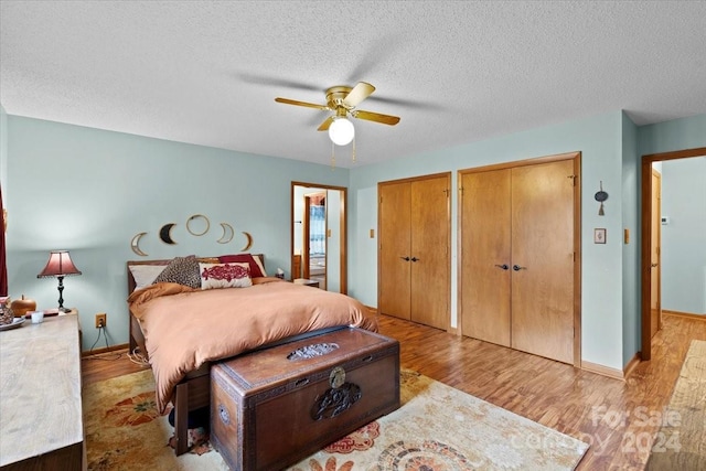 bedroom featuring light wood-type flooring, a textured ceiling, and ceiling fan