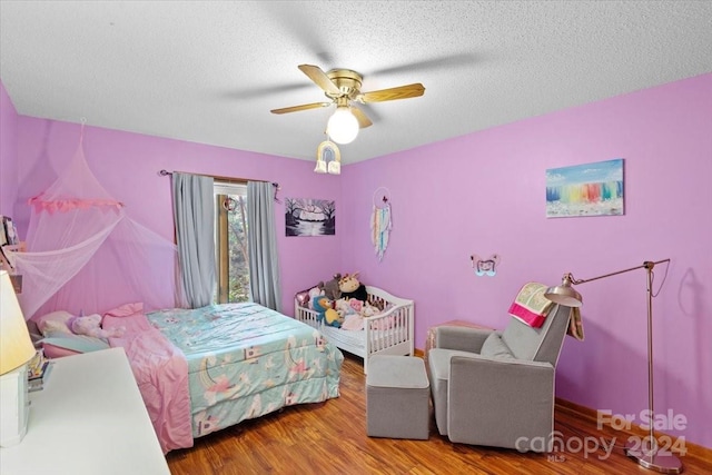 bedroom featuring hardwood / wood-style floors, ceiling fan, and a textured ceiling