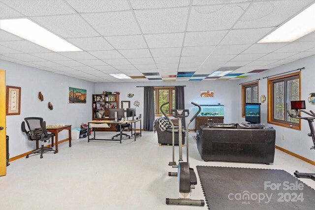 workout room with light colored carpet and a drop ceiling