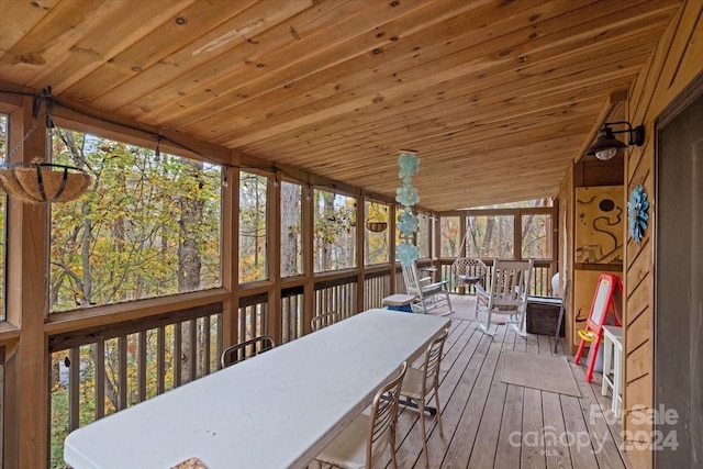 sunroom featuring lofted ceiling and wood ceiling