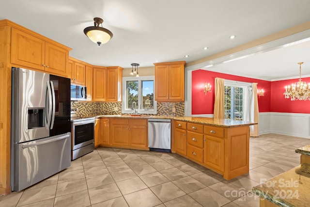 kitchen with tasteful backsplash, light stone countertops, appliances with stainless steel finishes, kitchen peninsula, and pendant lighting