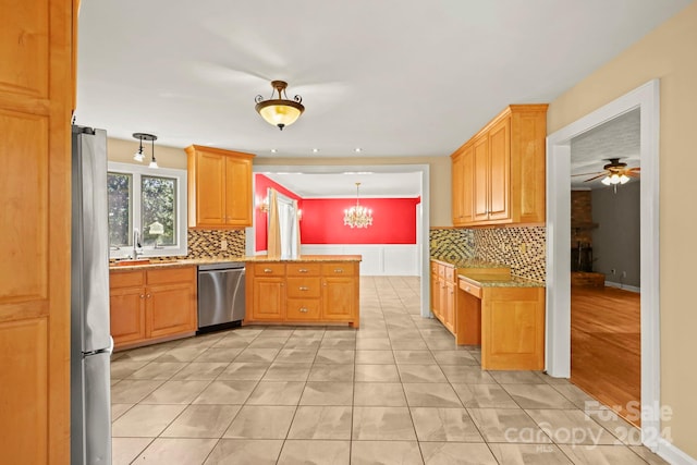 kitchen featuring appliances with stainless steel finishes, decorative backsplash, decorative light fixtures, and ceiling fan with notable chandelier