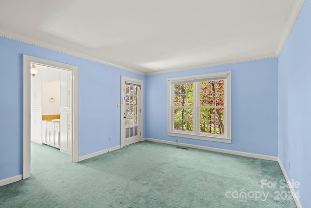 carpeted spare room with crown molding