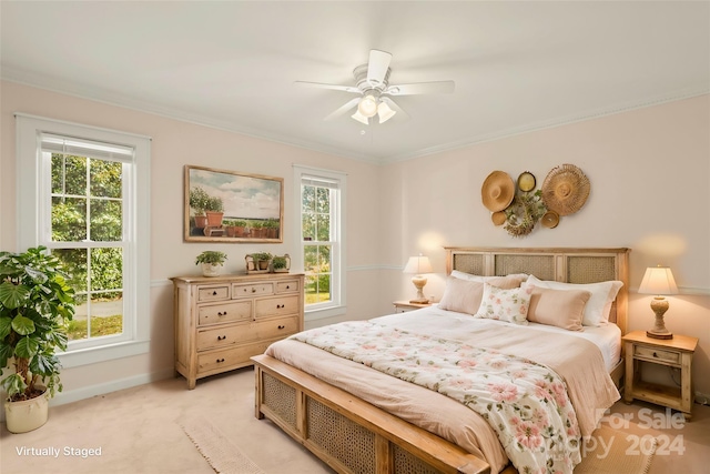 carpeted bedroom with ornamental molding and ceiling fan