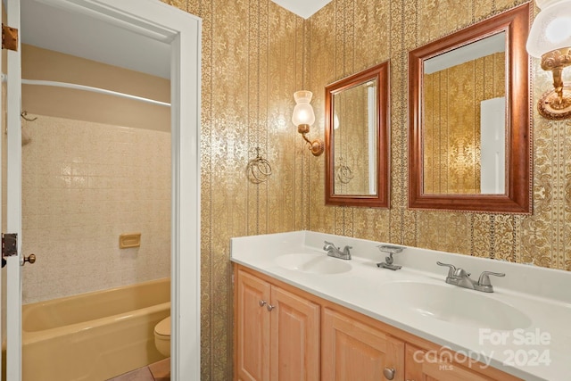 full bathroom with tiled shower / bath, vanity, and toilet