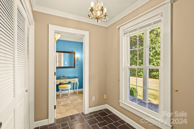 entryway with crown molding and a chandelier