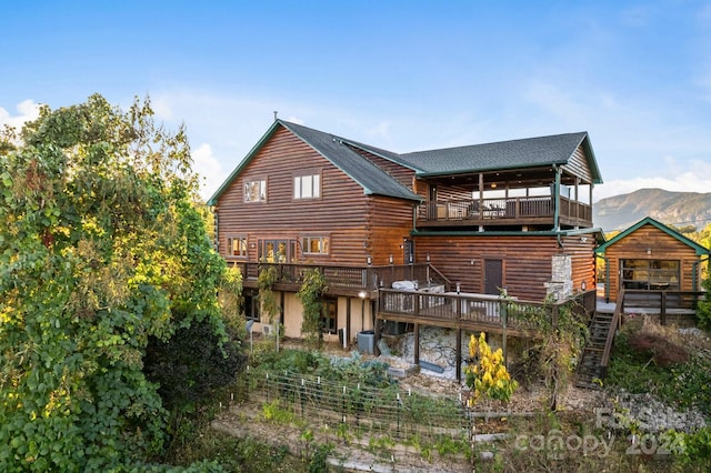 back of property featuring a deck with mountain view, a balcony, and central AC unit