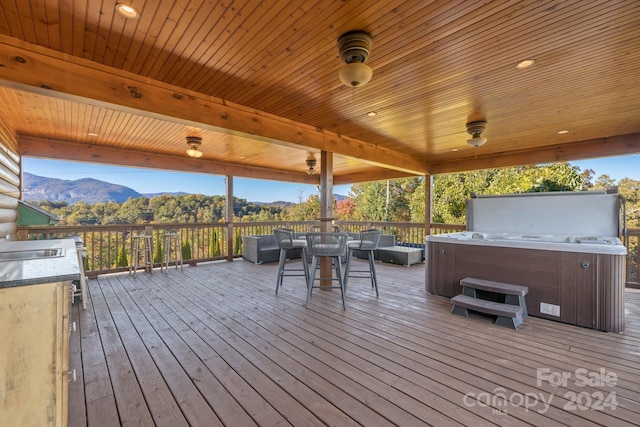 wooden terrace featuring a mountain view and a hot tub