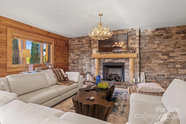 living room featuring wood walls, a chandelier, and a fireplace