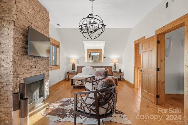 bedroom featuring light hardwood / wood-style flooring, a notable chandelier, and lofted ceiling