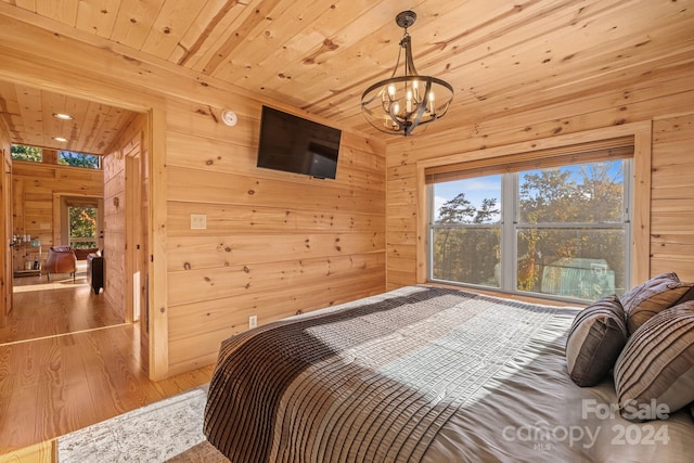 bedroom featuring an inviting chandelier, wood walls, wooden ceiling, and wood-type flooring