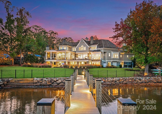 dock area featuring a lawn and a water view