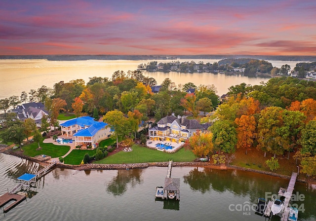 aerial view at dusk featuring a water view