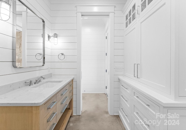 bathroom with wood walls and vanity