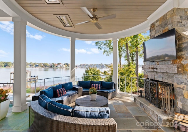 view of patio featuring an outdoor living space with a fireplace and ceiling fan