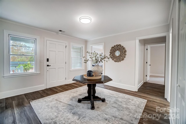 entrance foyer featuring dark wood-type flooring and crown molding