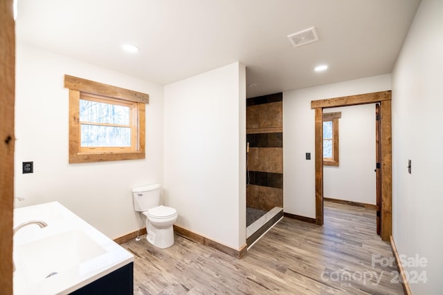 486 Hunter-Lysik Way, Laurel Springs, NC 28644 - bathroom featuring double vanity, toilet, tiled shower, wood finished floors, and baseboards