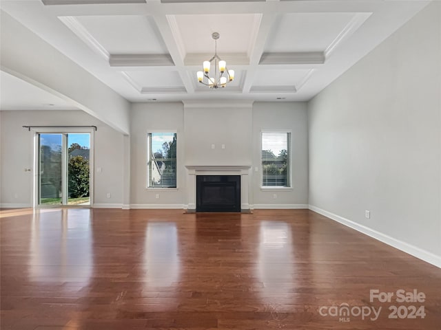 unfurnished living room with coffered ceiling, beamed ceiling, dark hardwood / wood-style flooring, and a chandelier